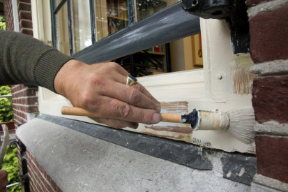 Kozijn van een monumentaal gebouw wordt geschilderd