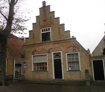 huis met trapgevel van gele steen met versieringen in rode steen in bogen boven de vensters, toppilaster en twee stoepstenen op Commandeurstraat 30 in West-Terschelling - MarcoSwart